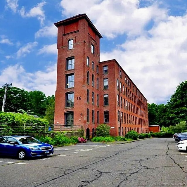 view of building exterior featuring uncovered parking