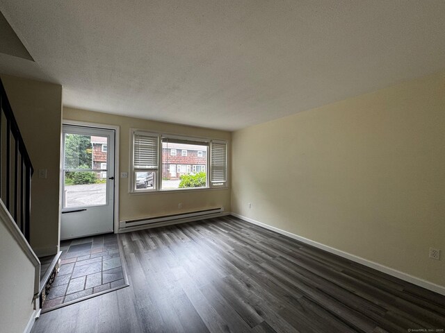 148 Westbury Park Rd Apt D, Watertown, CT 06795 - unfurnished living room featuring a baseboard heating unit, dark wood-style flooring, stairway, and a textured ceiling