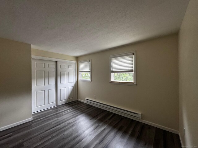 148 Westbury Park Rd Apt D, Watertown, CT 06795 - unfurnished bedroom with a baseboard radiator, a textured ceiling, dark wood finished floors, and a closet