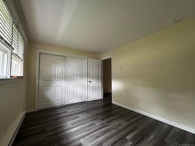 148 Westbury Park Rd Apt D, Watertown, CT 06795 - unfurnished bedroom featuring dark wood finished floors, a baseboard heating unit, and a closet
