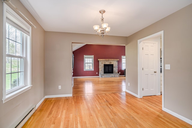 39 Overlook Dr, New Milford, CT 06776 - unfurnished living room with a baseboard radiator, light wood finished floors, a chandelier, and a wealth of natural light