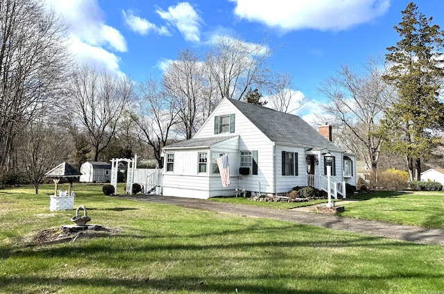 bungalow-style house featuring a shingled roof, a chimney, and a front yard