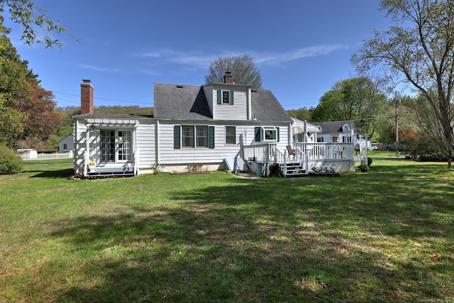 back of property featuring a lawn, a pergola, a wooden deck, and a chimney