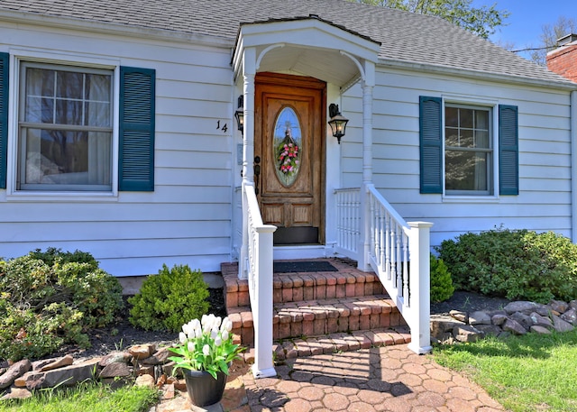property entrance featuring a shingled roof and a chimney