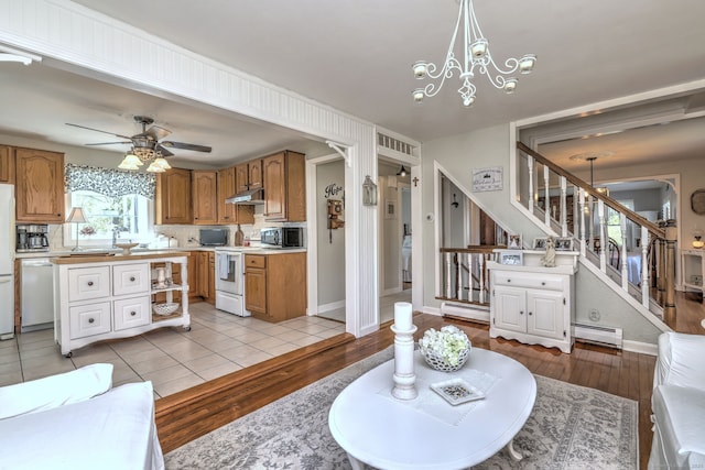 living area featuring light wood-style floors, stairway, a baseboard heating unit, and ceiling fan with notable chandelier