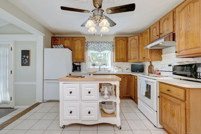 kitchen featuring white appliances, ceiling fan, light countertops, under cabinet range hood, and tasteful backsplash