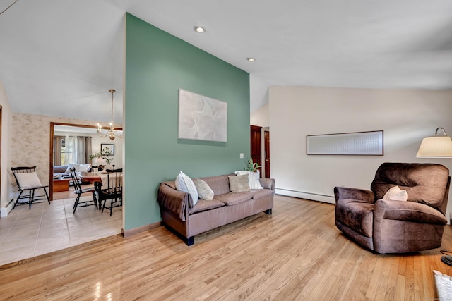 living area featuring baseboards, a baseboard radiator, a chandelier, wood finished floors, and high vaulted ceiling