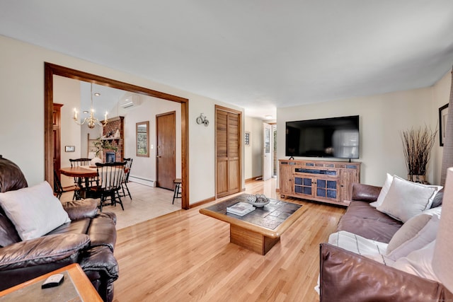 living room featuring a notable chandelier, baseboards, a wall unit AC, light wood finished floors, and a baseboard radiator