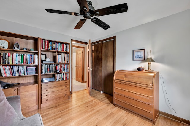 interior space with light wood finished floors, baseboards, and a ceiling fan