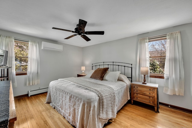 bedroom featuring baseboard heating, multiple windows, a wall unit AC, and light wood-style flooring