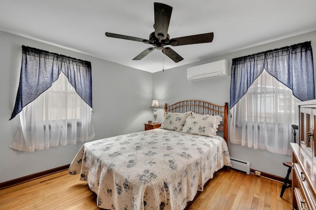 bedroom featuring baseboards, a ceiling fan, a wall unit AC, wood-type flooring, and a baseboard radiator