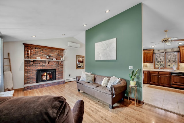 living room featuring a wall mounted air conditioner, a fireplace, light wood finished floors, vaulted ceiling, and a baseboard heating unit
