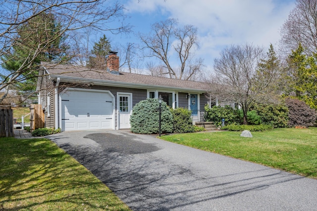 ranch-style house with a chimney, a garage, driveway, and a front lawn