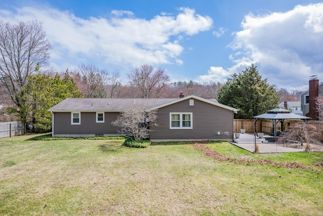 rear view of property featuring a gazebo, a patio area, fence, and a yard