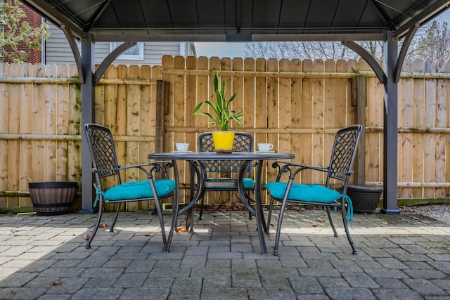 view of patio featuring a gazebo, fence, and outdoor dining area