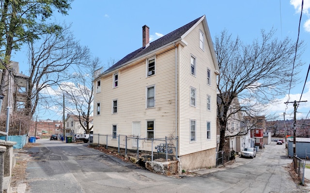 36 Gilbert St, Waterbury, CT 06702 - back of house with a residential view, a chimney, and fence