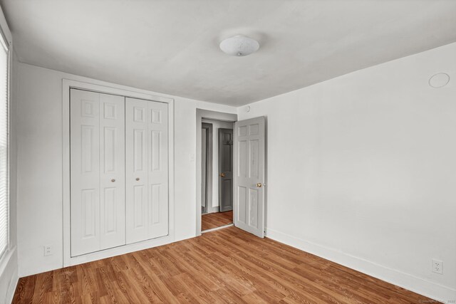 36 Gilbert St, Waterbury, CT 06702 - unfurnished bedroom with a closet, baseboards, and wood finished floors