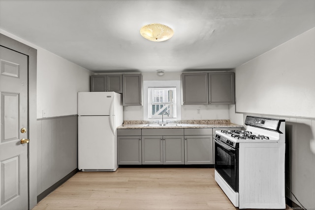36 Gilbert St, Waterbury, CT 06702 - kitchen featuring light wood-style floors, freestanding refrigerator, gray cabinets, gas range, and a sink
