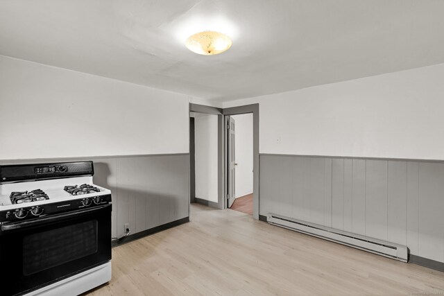 36 Gilbert St, Waterbury, CT 06702 - kitchen with light wood-style floors, a baseboard heating unit, range with gas cooktop, and wainscoting