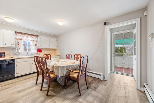 dining room with a wealth of natural light, light wood-style floors, and a baseboard heating unit
