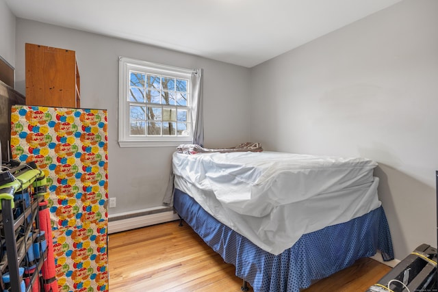 bedroom featuring baseboard heating and light wood-type flooring