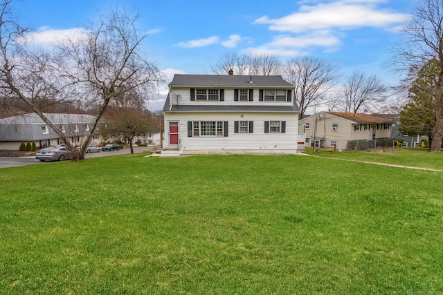 view of front of house featuring entry steps, a front lawn, and a chimney
