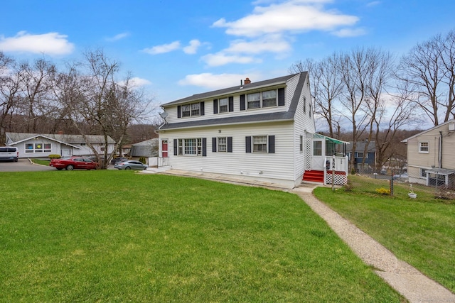 view of front facade with a front yard, fence, and a chimney
