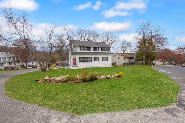 traditional home with a front lawn and a chimney