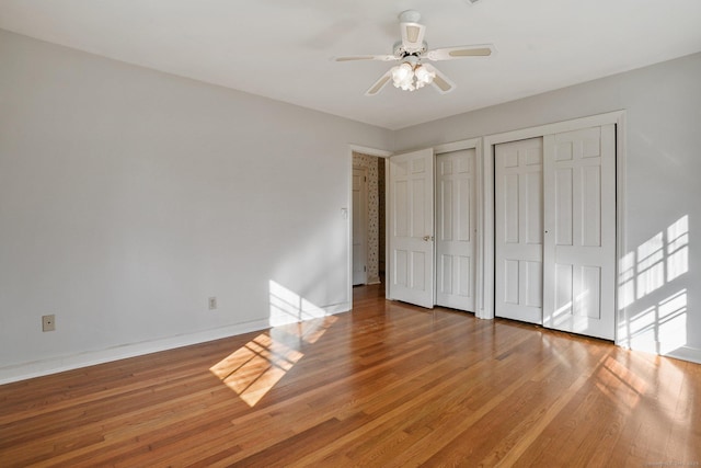 97 Wyldewood Rd, Easton, CT 06612 - unfurnished bedroom featuring multiple closets, wood finished floors, baseboards, and a ceiling fan