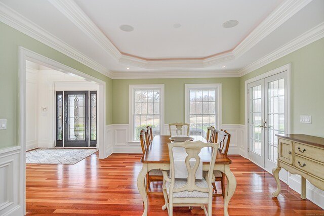 48 Mount Nebo Rd, Newtown, CT 06470 - dining space featuring light wood-style flooring, french doors, a decorative wall, a tray ceiling, and wainscoting