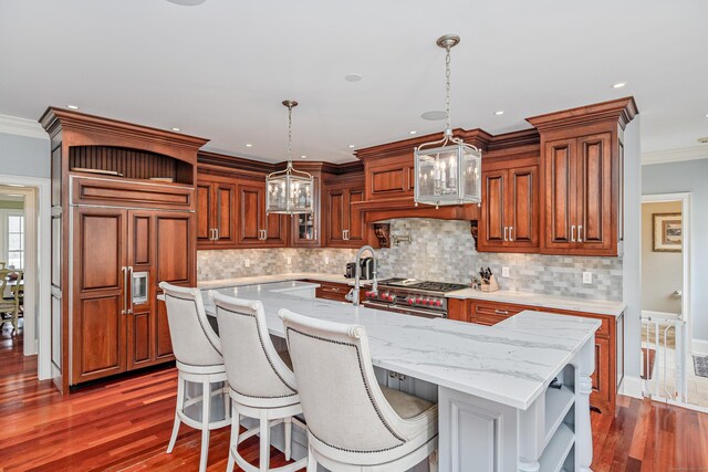 48 Mount Nebo Rd, Newtown, CT 06470 - kitchen featuring open shelves, wood finished floors, a center island with sink, hanging light fixtures, and crown molding