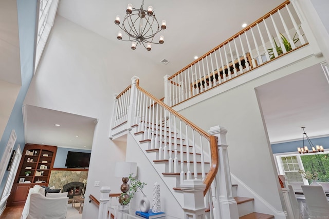 211 Linden Tree Rd, Wilton, CT 06897 - stairway featuring a chandelier, a towering ceiling, a stone fireplace, and recessed lighting