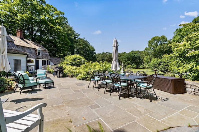 view of patio with outdoor dining space and a grill