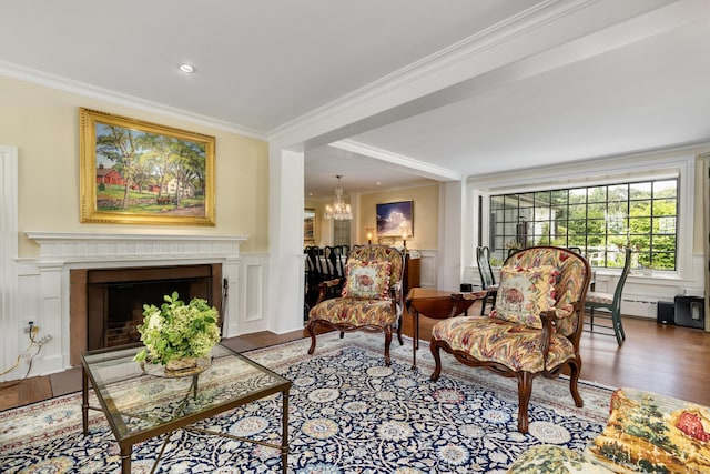 living area featuring crown molding, wood finished floors, an inviting chandelier, and a decorative wall