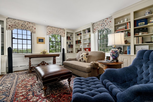 sitting room with wood finished floors and built in shelves