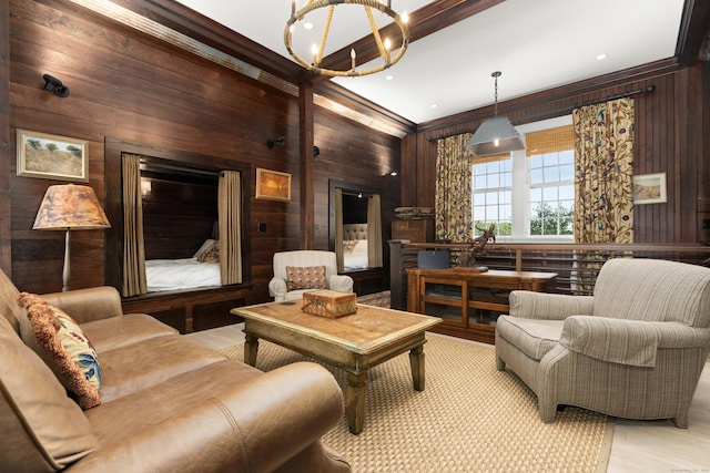 sitting room with light wood-type flooring, wooden walls, a chandelier, and crown molding