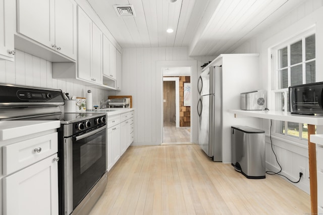 kitchen featuring stainless steel appliances, visible vents, light wood-style floors, and white cabinetry