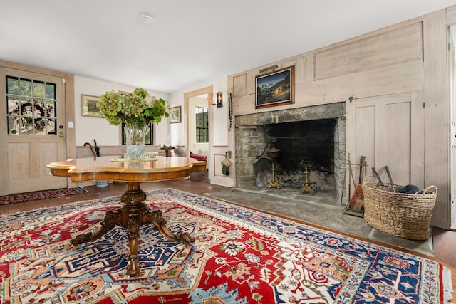 living area with a fireplace with flush hearth and wood finished floors