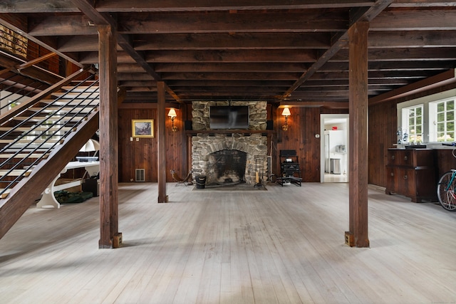 interior space featuring visible vents, wood walls, stairway, a fireplace, and wood-type flooring