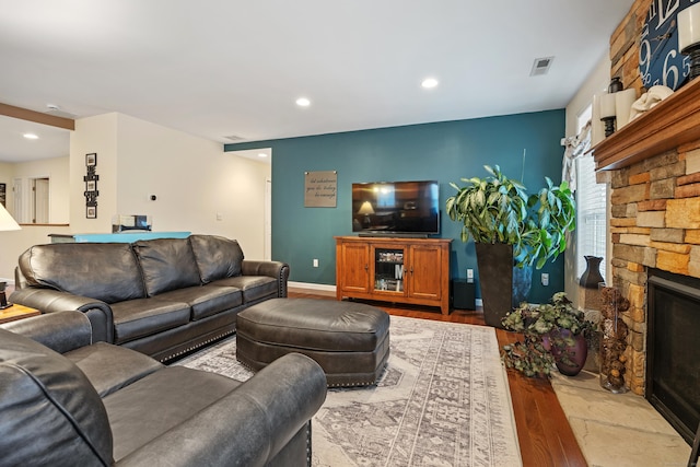 living room featuring wood finished floors, a fireplace, and recessed lighting