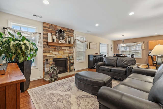 living area with wood finished floors, healthy amount of natural light, a fireplace, recessed lighting, and baseboards