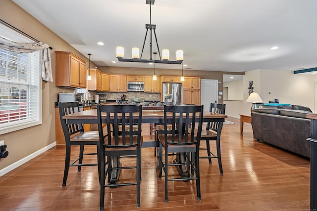 dining room with baseboards, wood finished floors, healthy amount of natural light, and recessed lighting