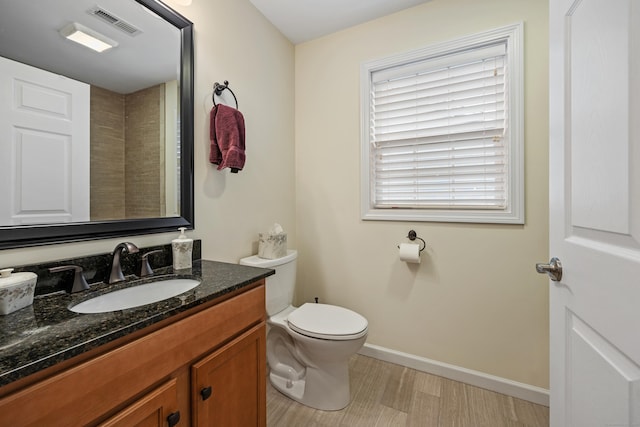 bathroom featuring baseboards, vanity, toilet, and wood finished floors