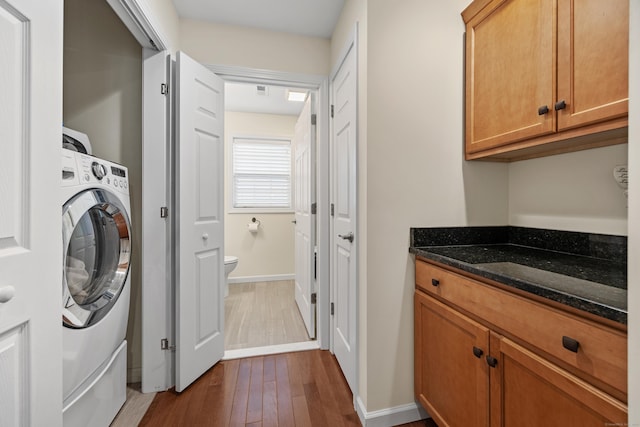 laundry room with washer / clothes dryer, dark wood finished floors, and baseboards