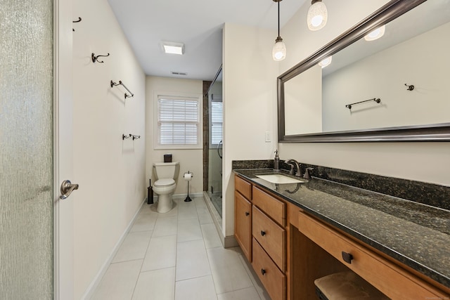 full bathroom featuring toilet, tile patterned floors, vanity, a stall shower, and baseboards