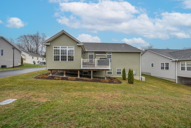 back of property with a lawn and a wooden deck