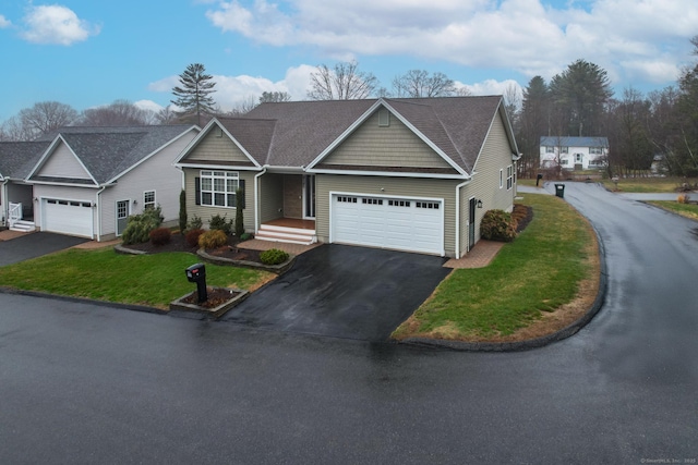 view of front of property featuring driveway, a garage, a front lawn, and a shingled roof