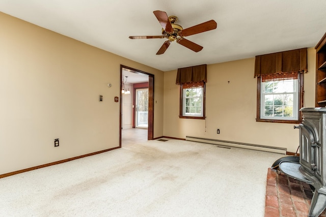 14 Valley View Dr, Wallingford, CT 06492 - unfurnished living room with light carpet, a healthy amount of sunlight, a wood stove, and a baseboard radiator