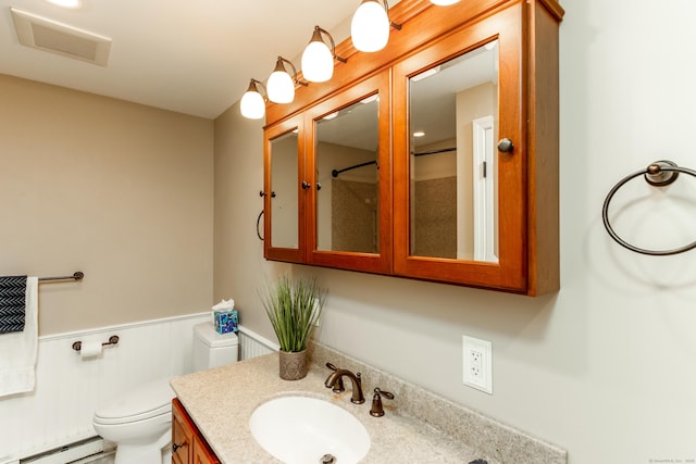 14 Valley View Dr, Wallingford, CT 06492 - bathroom with visible vents, vanity, toilet, baseboard heating, and a wainscoted wall