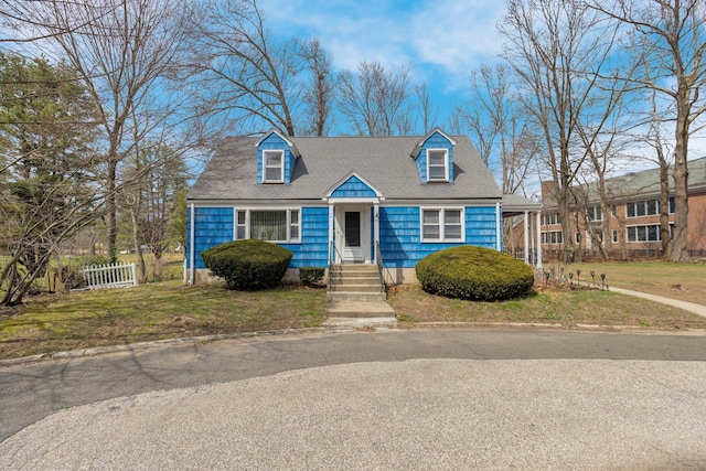cape cod-style house with a front yard and fence